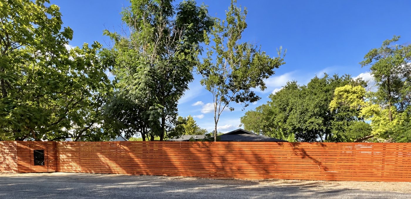 The finished bungalow exterior with the custom horizontal wood fence