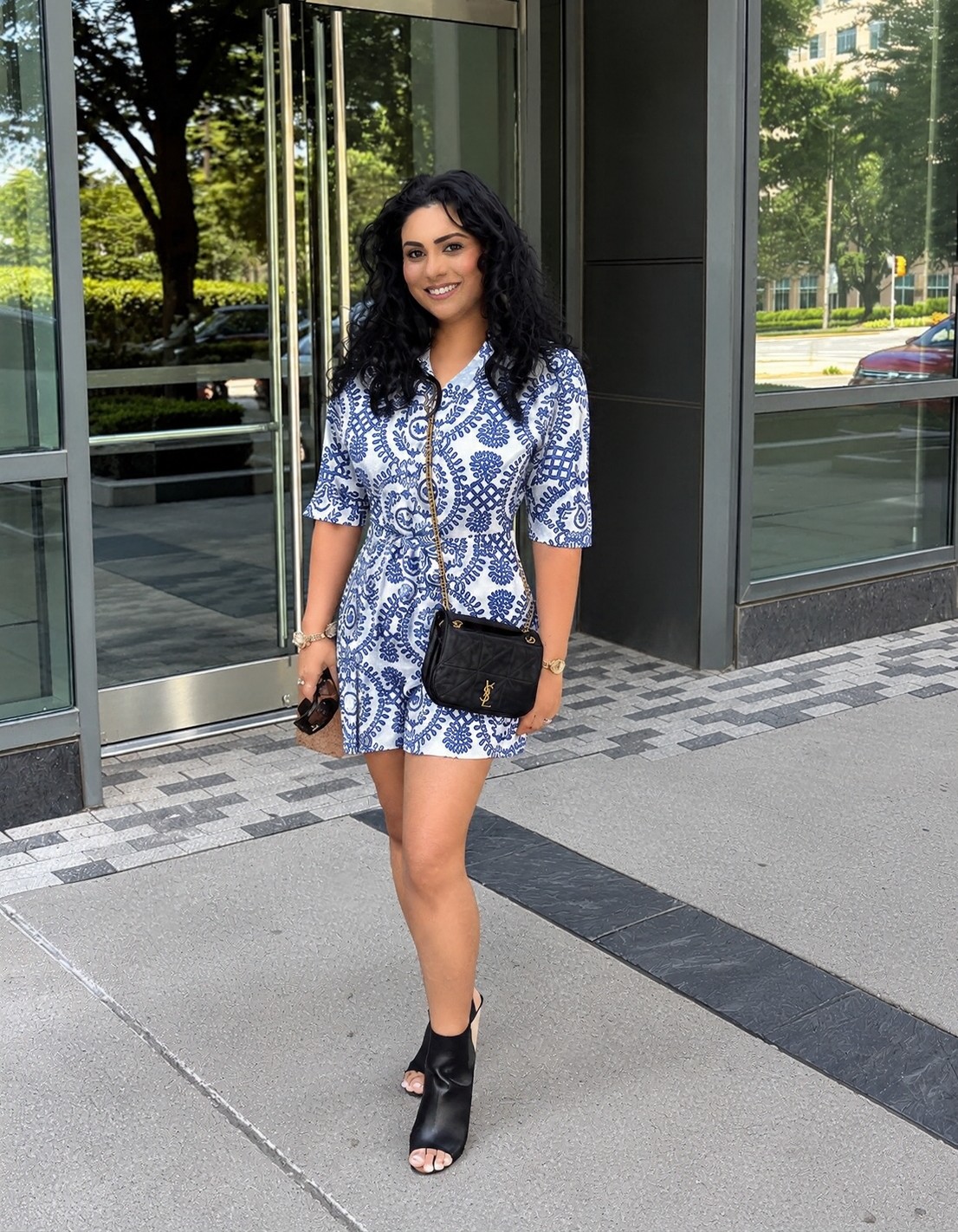 Anabin Islam smiling in a blue and white printed romper outside a glass building